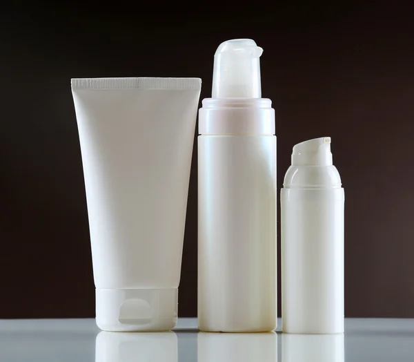 Group of cosmetic bottles on dark background — Stock Photo, Image