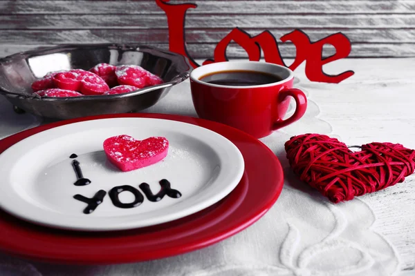 Печиво у формі серця на тарілці з написом Я люблю тебе на кольоровому дерев'яному столі фоні — стокове фото