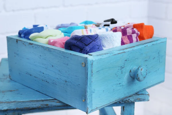 Socks in color drawer on white brick wall background — Stock Photo, Image