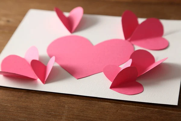 Mooie handgemaakte postkaart met papier harten op een houten achtergrond kleur — Stockfoto