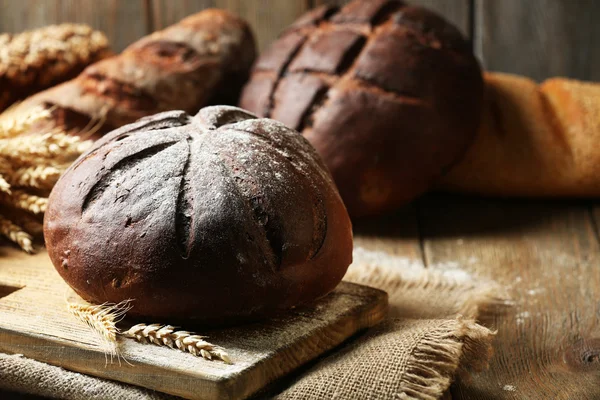 Tasty bread on table on wooden background — Stock Photo, Image