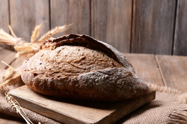 Вкусный хлеб на столе на деревянном фоне — стоковое фото