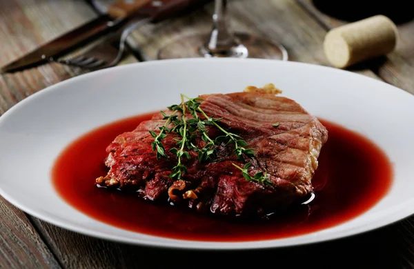 Steak grillé à la sauce au vin dans une assiette sur la table fermer — Photo