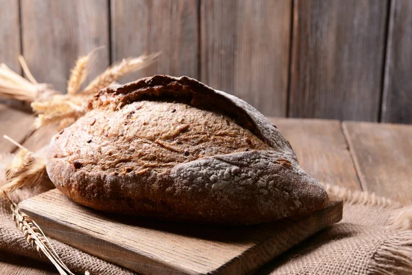 Tasty bread on table on wooden background Royalty Free Stock Images