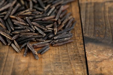 ahşap arka plan üzerinde siyah pirinç taneleri