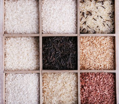 Pirinç kutusunda ahşap arka plan üzerinde farklı türleri