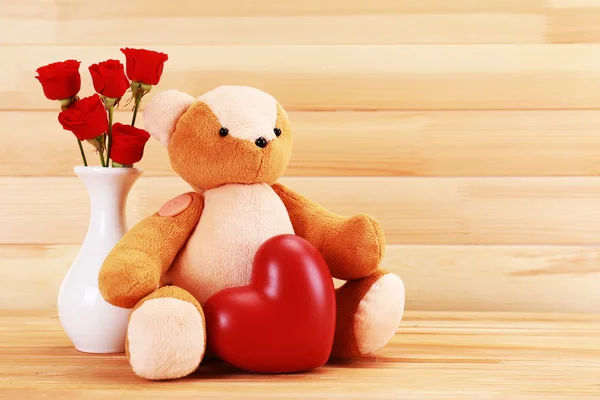 Teddy bear with heart and roses on wooden background, love concept — Stock Photo, Image