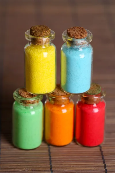 Pigmentler bambu Hasır arka plan üzerinde renkli şişe Makinası — Stok fotoğraf
