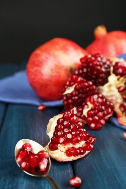 Koyu arka plan üzerinde ahşap masa üzerinde sulu olgun nar