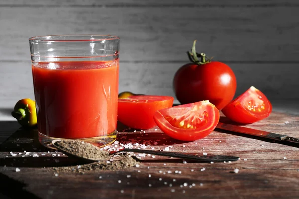 Ποτήρι χυμό ντομάτας με μπαχαρικά και φρέσκες ντομάτες στο ξύλινο τραπέζι. με σκούρο φόντο — Φωτογραφία Αρχείου