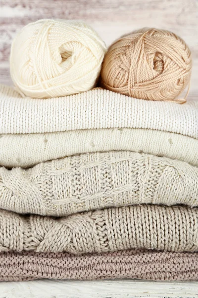 Knitting clothes and yarn on wooden background — Stock Photo, Image