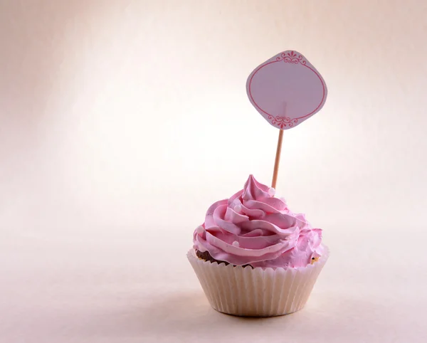 Delicious cupcake with inscription on table on beige background — Stock Photo, Image