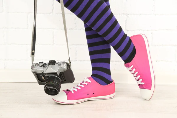 Chica en zapatillas con cámara de fotos retro en la habitación — Foto de Stock