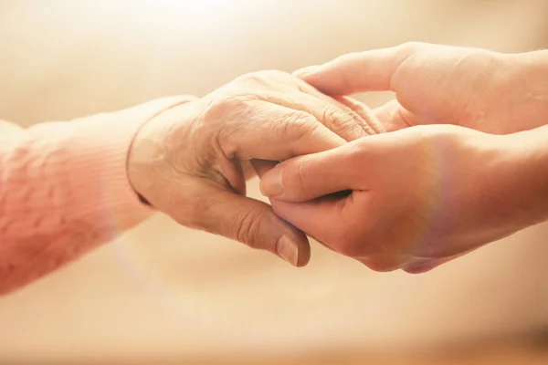 Old and young holding hands Stock Picture