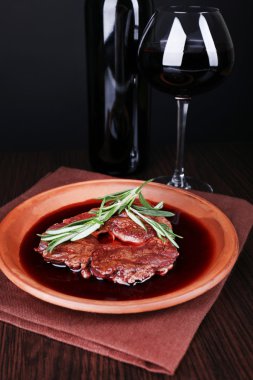 Koyu arka plan üzerinde şarap ile şarap soslu ızgara biftek