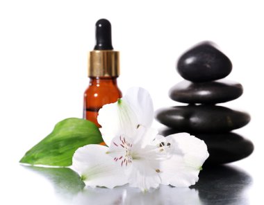 Spa taşlarla aromatik yağlar ve üzerinde beyaz izole çiçek