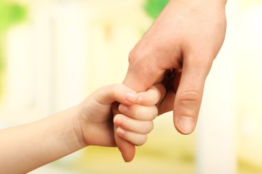Çocuk ve babası eller üzerinde parlak arka plan