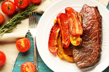 Lezzetli kızarmış et ve sebze ahşap arka plan üzerinde plaka ile kompozisyon