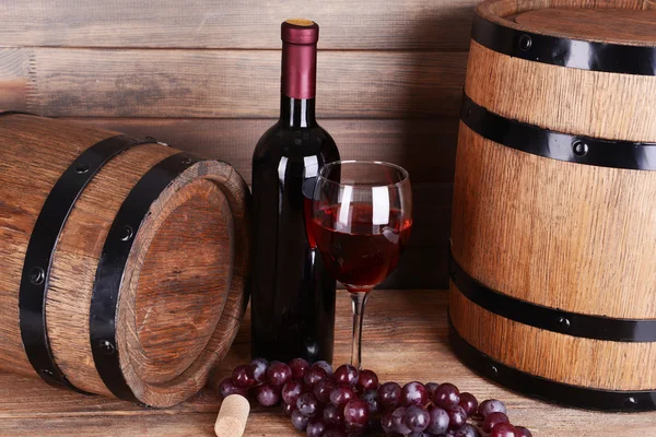 Vinho tinto na mesa no fundo de madeira — Fotografia de Stock