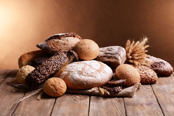 Different bread on table on brown background