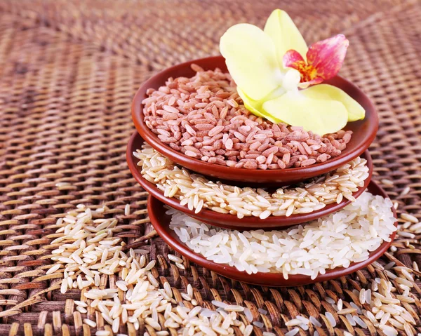Diferentes tipos de arroz em tigelas no fundo de vime — Fotografia de Stock