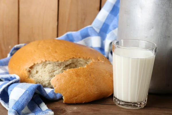 Retro can for milk with fresh bread and glass of milk on wooden background. Bio products concept — Stock Photo, Image