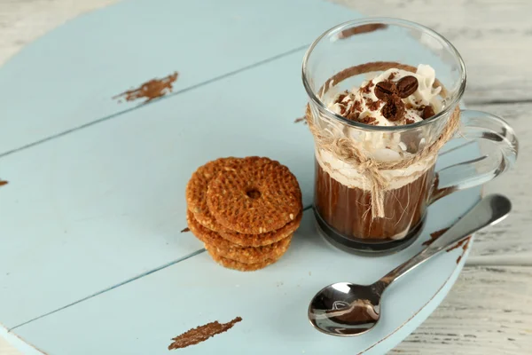 Чашка кофе со сливками и печеньем на деревянном фоне — стоковое фото