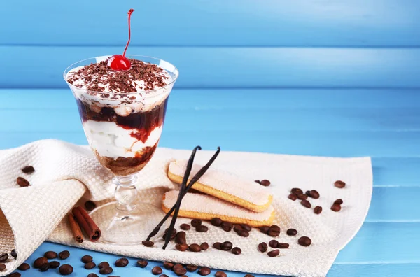 Tasty tiramisu dessert in glass, on color wooden background — Stock Photo, Image