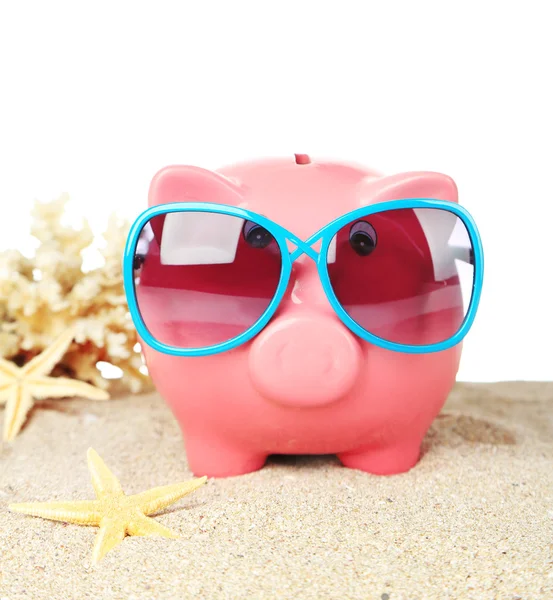Piggy bank met zonnebril op zand, op witte achtergrond — Stockfoto