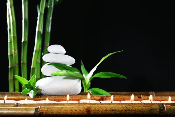 Hermosa composición con piedras de spa y velas en la mesa sobre fondo oscuro —  Fotos de Stock