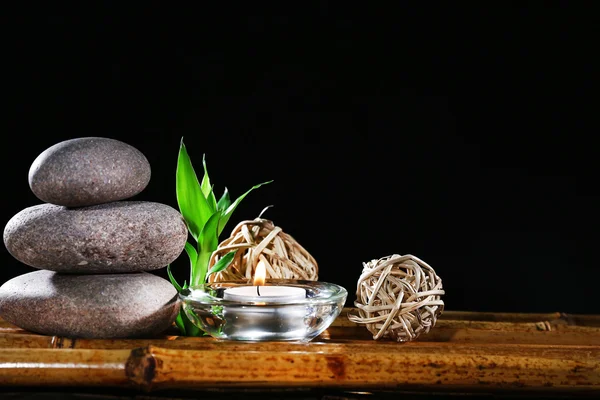 Beautiful composition with spa stones and candle on table on dark background — Stock Photo, Image