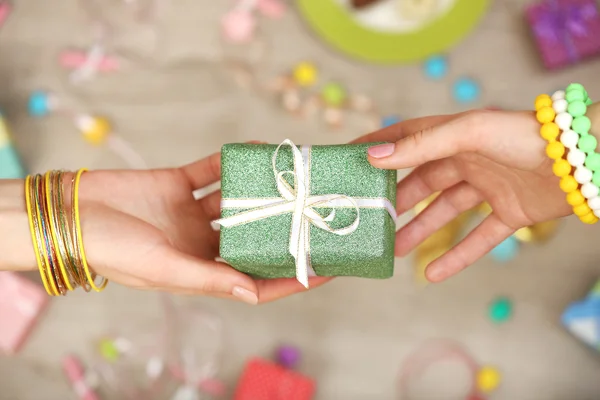 Vrouwelijke handen met cadeau — Stockfoto