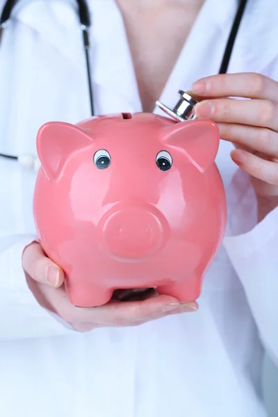 Doctor with pink piggy bank — Stock Photo, Image