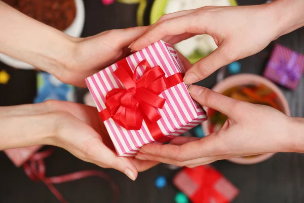 Vrouwelijke handen met cadeau — Stockfoto