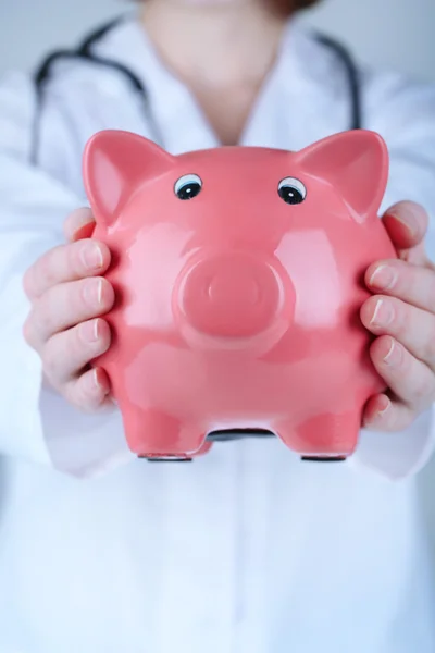 Doctor with pink piggy bank — Stock Photo, Image