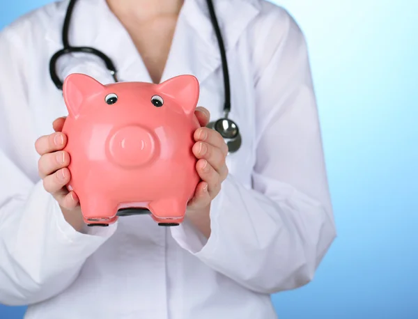 Doctor with pink piggy bank — Stock Photo, Image