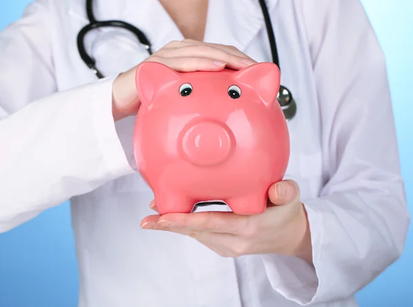 Doctor with pink piggy bank — Stock Photo, Image