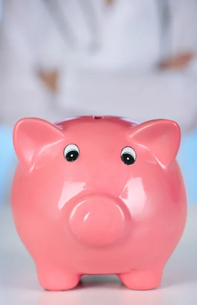 Doctor with pink piggy bank — Stock Photo, Image