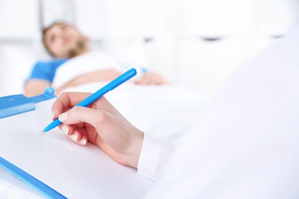 Doctor filling medical report for her patient close up — Stock Photo, Image