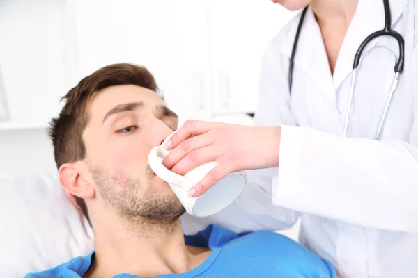 Médico da a beber paciente de cerca — Foto de Stock