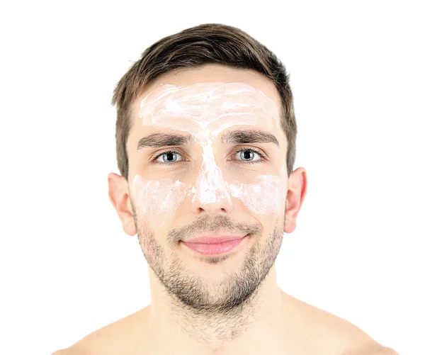 Bonito jovem com creme loção no rosto isolado no branco — Fotografia de Stock
