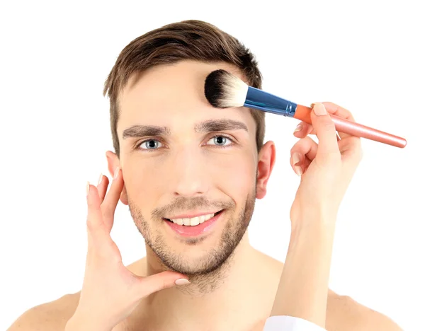 Weibliche Hand beim Make-up junger Mann isoliert auf weiß — Stockfoto