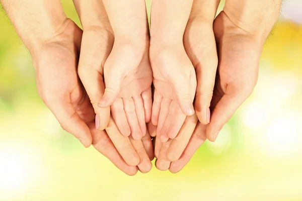 Mani di famiglia su sfondo luminoso — Foto Stock