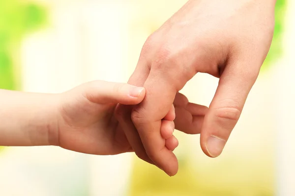 Enfant et père mains sur fond lumineux — Photo