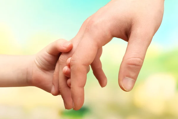 Enfant et père mains sur fond lumineux — Photo