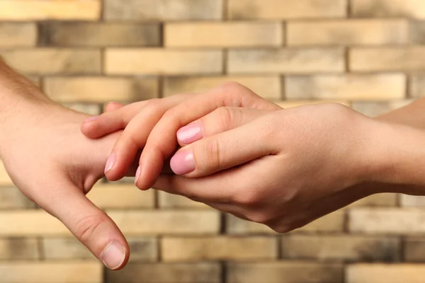 Manos masculinas y femeninas sobre fondo de pared — Foto de Stock