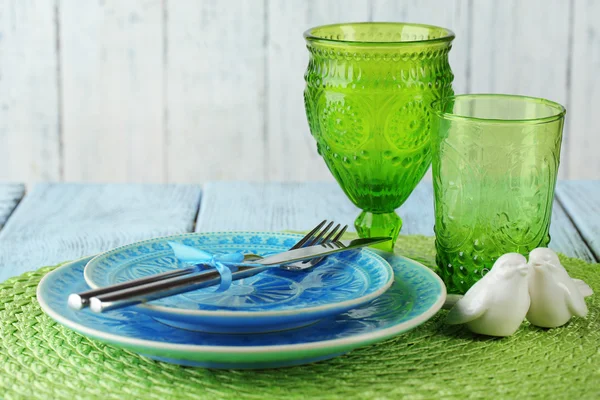 Assiette colorée vide, verres et argenterie sur table en bois — Photo