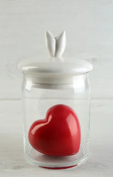 Decorative heart in glass jar on light background — Stock Photo, Image