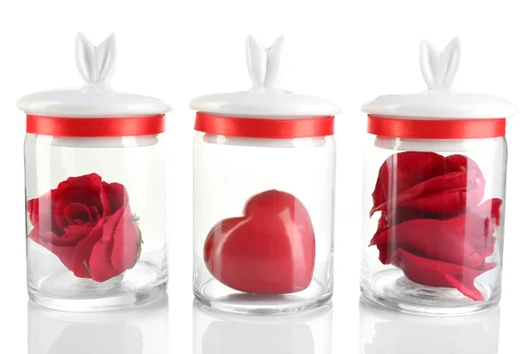 Fiore di rosa, petali e cuore decorativo in vasi di vetro isolati su bianco — Foto Stock