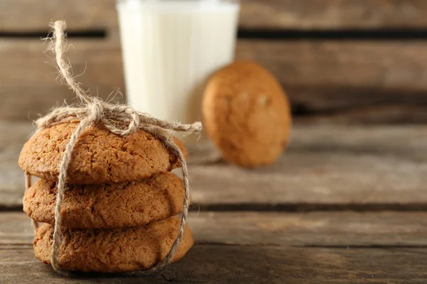 Tasty cookies and glass of milk on rustic wooden background — Stock Photo, Image